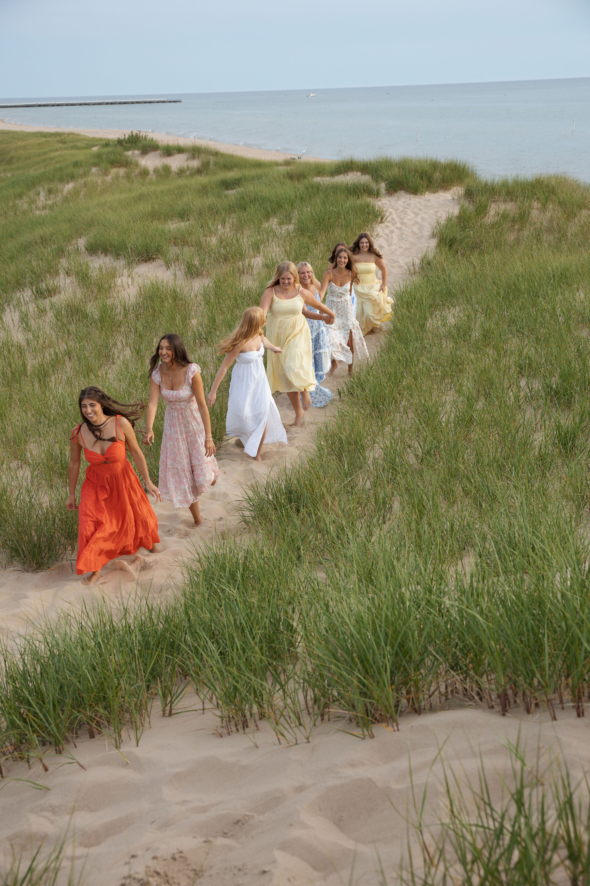 Group of friends walking a beach path at golden hour